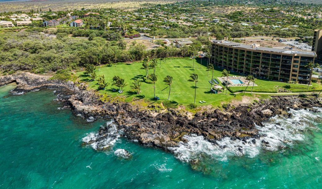 Aerial view of Kihei Surfside condo complex in South Kihei, Maui with oceanfront lawn and views of Haleakalā