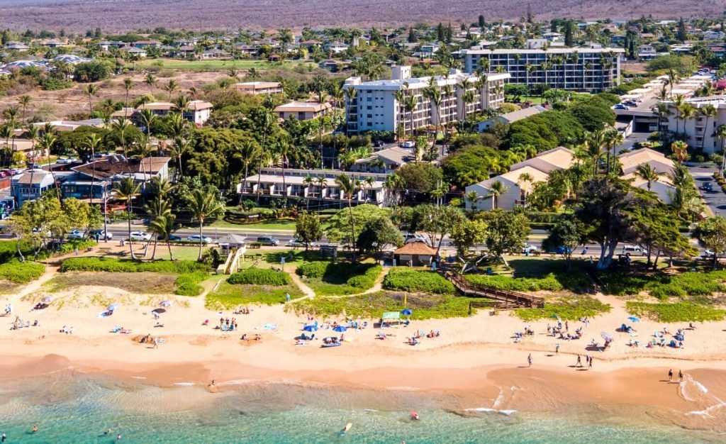 Aerial view of Kihei Akahi condo complex in South Kihei, Maui, located across from Kamaole Beach Park II with beachfront access and lush surroundings