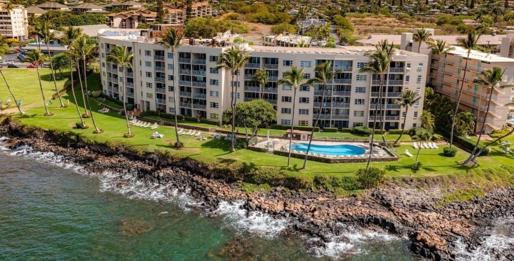 Aerial view of Royal Mauian oceanfront condo complex in South Kihei, Maui, with oceanside pool, rooftop deck, and panoramic Pacific Ocean views
