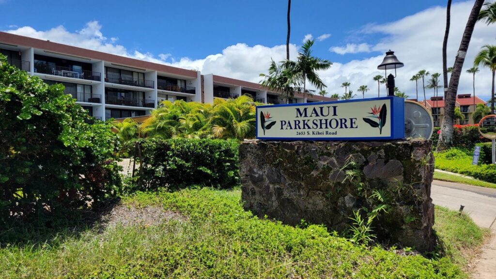 Maui Parkshore condo complex entrance sign with oceanview buildings in the background, located across from Kamaole Beach Park III in South Kihei, Maui