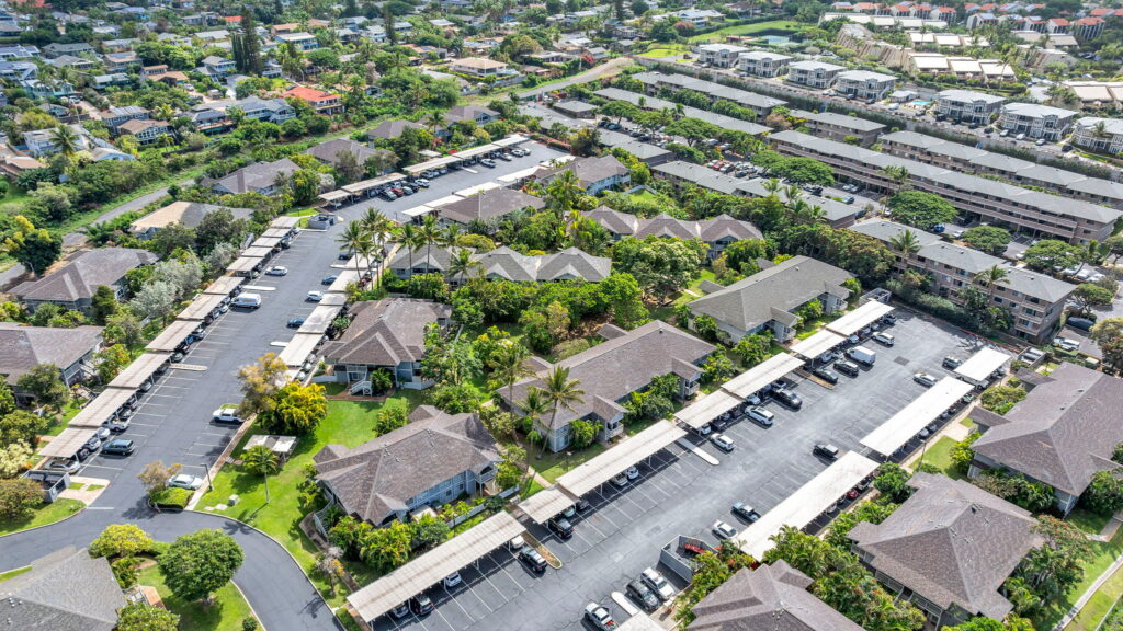 Aerial view of Keonekai Villages residential condo community with parking, landscaped grounds, and surrounding neighborhoods in South Kihei, Maui